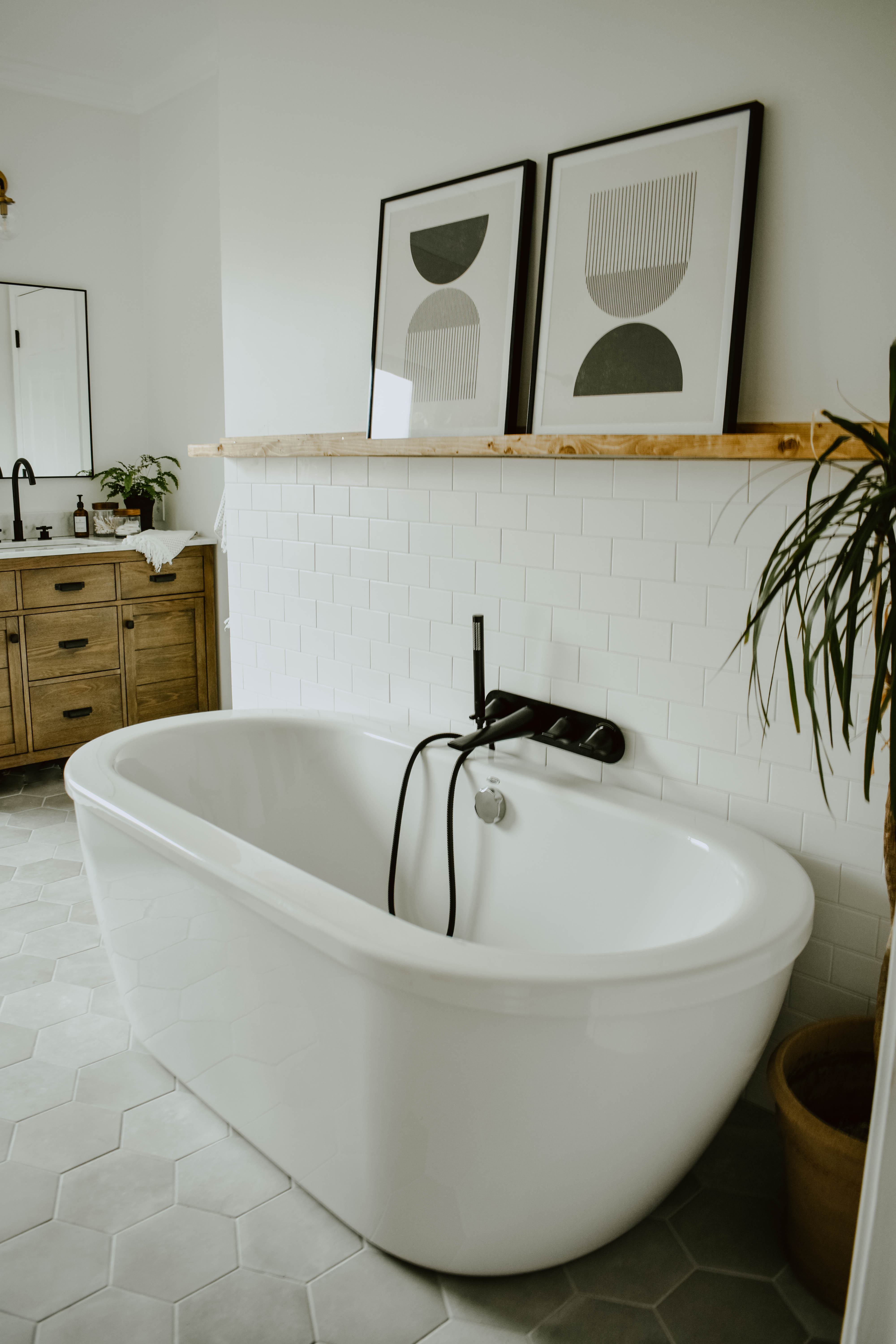 american standard free standing cadet bath tub with matte black tub filler and DIY picture ledge with modern block prints