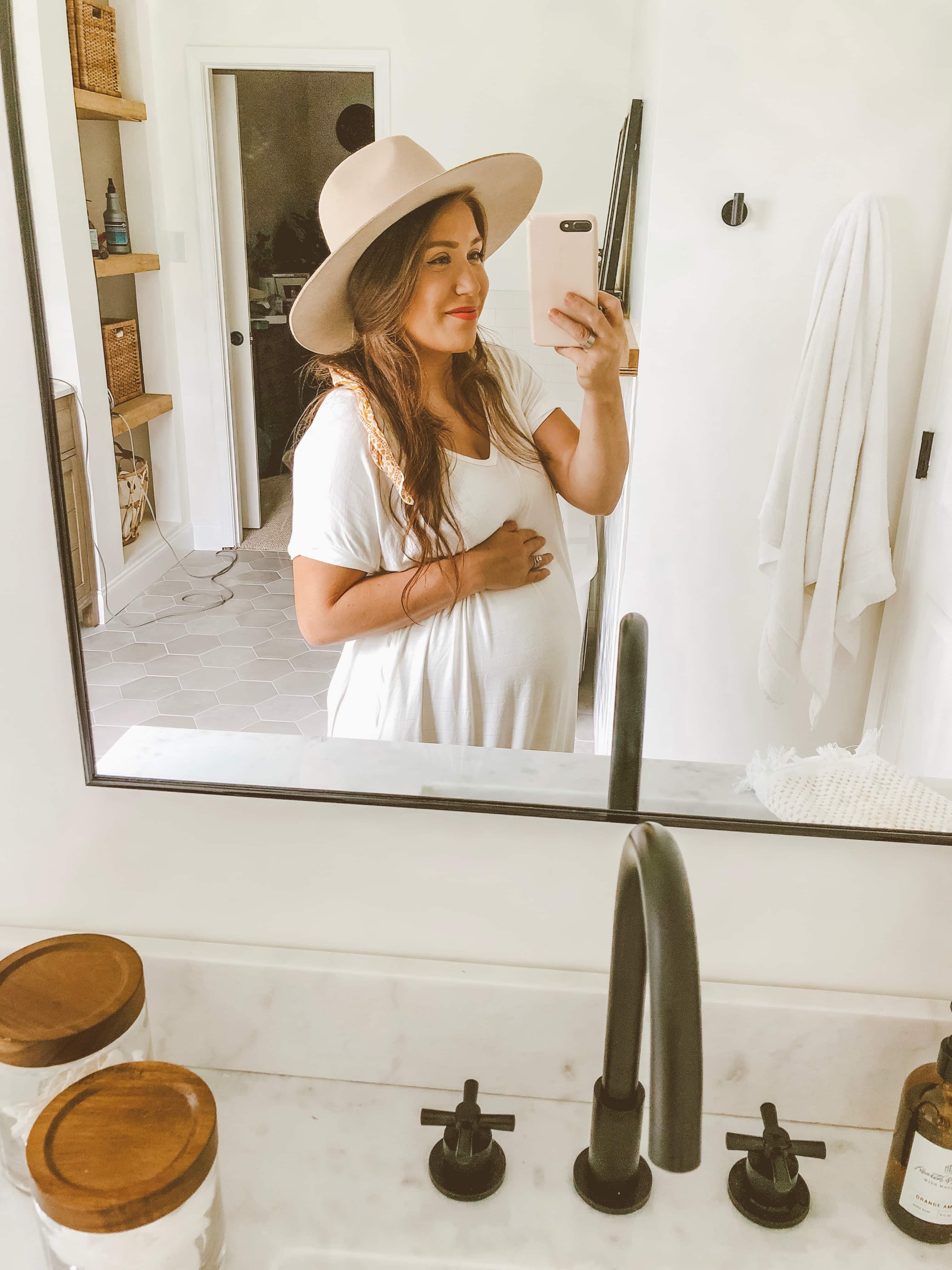 pregnant woman taking a mirror selfie
